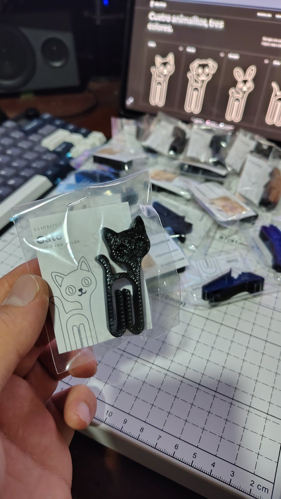 Clip de gatito negro en su sobre, con la tarjeta de Clipsitos detrás